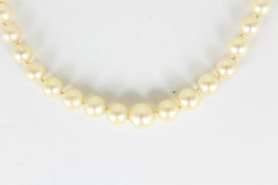 gros plan d'un collier de perles blanches sur une surface blanche