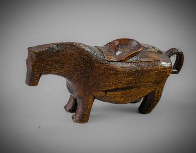 an image of a small wooden elephant with a saddle on it ' s back