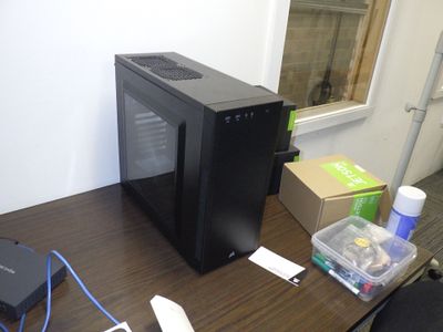 un ordinateur posé sur un bureau, avec une souris et d'autres objets