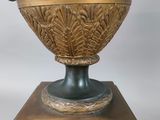 a large green vase with gold decoration on top of a pedestal