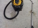 un aspirateur posé par terre à côté d'un autre aspirateur