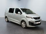 the silver van is parked in a large room with a clock on the wall
