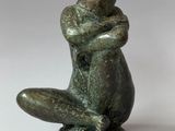statue of a man sitting on his knees with his arms crossed