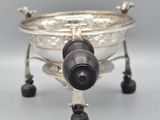 a silver bowl with wheels on it on a gray surface