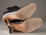 pair of black leather shoes with buckles on a grey surface