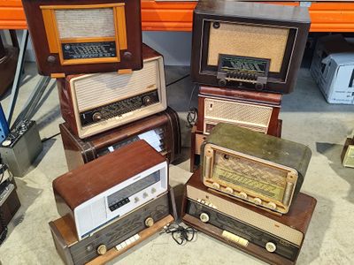several old fashioned radio ' s are stacked on top of each other