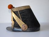 a black hat with gold trim and a button on it