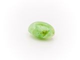 a close up of a green jade stone on a white surface
