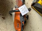 a small chainsaw sitting on the floor next to a tool box