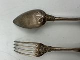 two spoons and a fork sitting on a table