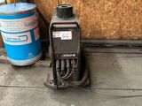 a machine that is sitting on the ground next to a bucket