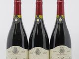 trois bouteilles de vin rouge sont alignées sur une surface blanche