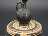 un vase noir posé sur un socle en bois