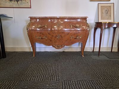 a chest of drawers in a room with pictures on the wall
