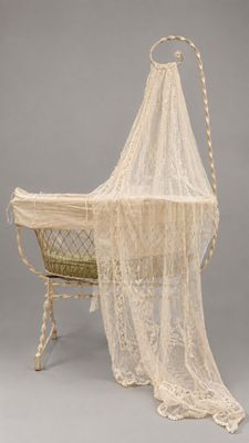 un berceau à l'ancienne avec un baldaquin en dentelle blanche et un panier en osier