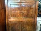 une grande armoire en bois surmontée d'un tiroir