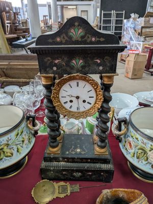 une horloge posée sur une table à côté de deux vases