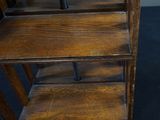 a wooden shelf that has a bunch of books on top of it