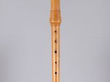 a close up of a wooden flute on a white surface