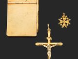 un crucifix en or représentant une croix et un livre