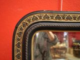 le reflet d'une femme dans un miroir accroché au mur