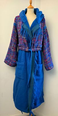 manteau violet et bleu à franges, posé sur un présentoir pour mannequin