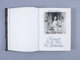 an open book with a picture of a woman sitting in a window