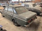 two old cars that are parked in a garage