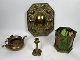 trois objets anciens en laiton et en verre posés sur une surface blanche