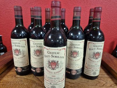 six bottles of wine are lined up on a wooden tray