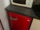 un micro-ondes et un petit réfrigérateur rouge dans une petite cuisine