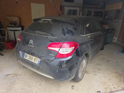 une voiture sale garée dans un garage
