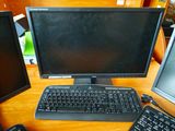 un écran d'ordinateur et un clavier posés sur un bureau