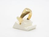 a gold ring sitting on top of a white marble block