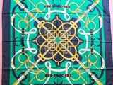 a green and black scarf with a gold and black design