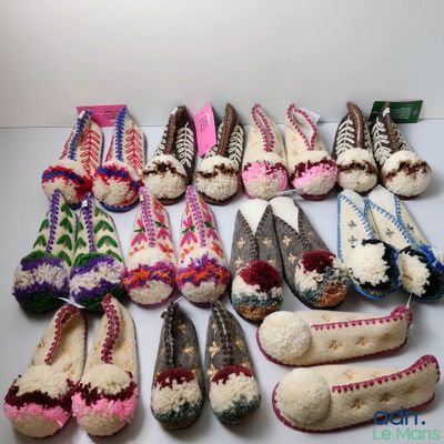 Plusieurs paires de chaussons sont alignées sur une table