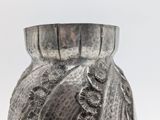 a silver vase that is sitting on a table