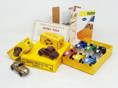 several toy cars are in a yellow box on a white surface
