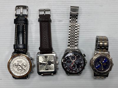 quatre montres différentes sont alignées sur une surface blanche