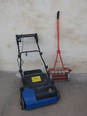 a blue and black lawn mower next to a red broom
