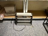 a heater that is sitting on the floor next to a shelf