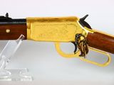 an antique rifle with a brass plated body and a wooden handle