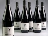 six bouteilles de vin sont alignées sur une table