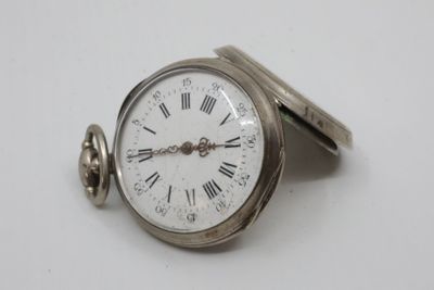 a silver pocket watch with roman numerals on it