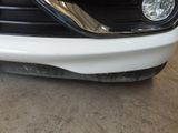 a close up of the front bumper of a white car