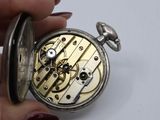 a person holding a silver pocket watch in their hand