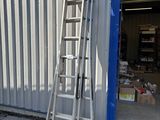 une échelle appuyée contre un immeuble, à côté d'une porte bleue