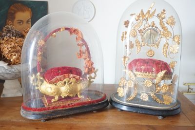 deux cloches en verre ornées de motifs dorés, posées sur une table