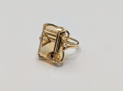 gros plan d'une bague en or avec une pierre en émeraude