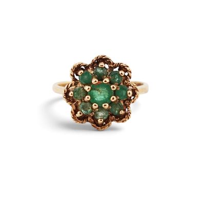 a close up of a gold ring with a green stone